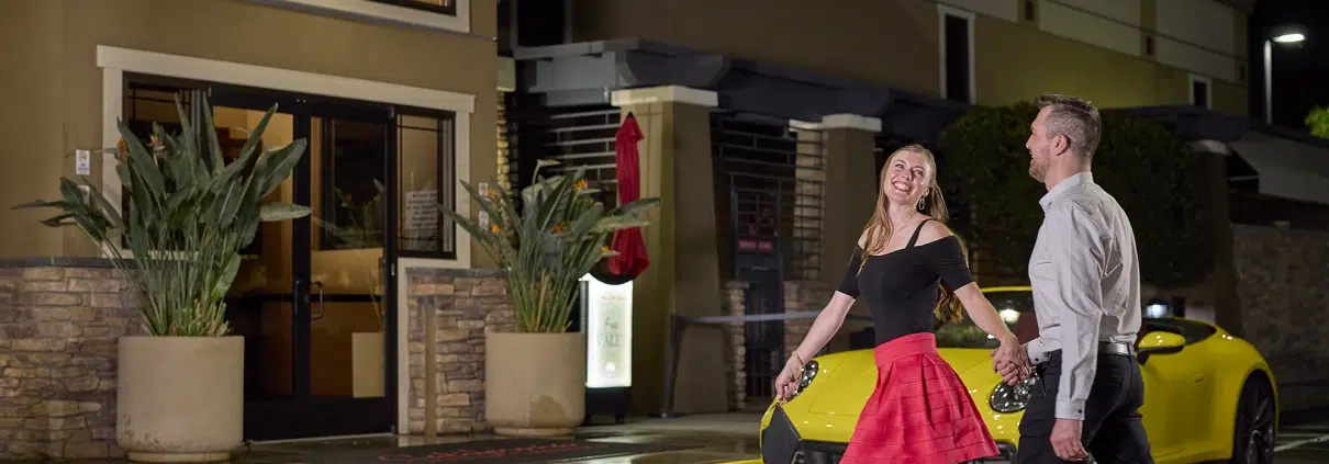 Happy couple arriving at California Grand Casino entrance, ready to enjoy table games, dining, and entertainment
