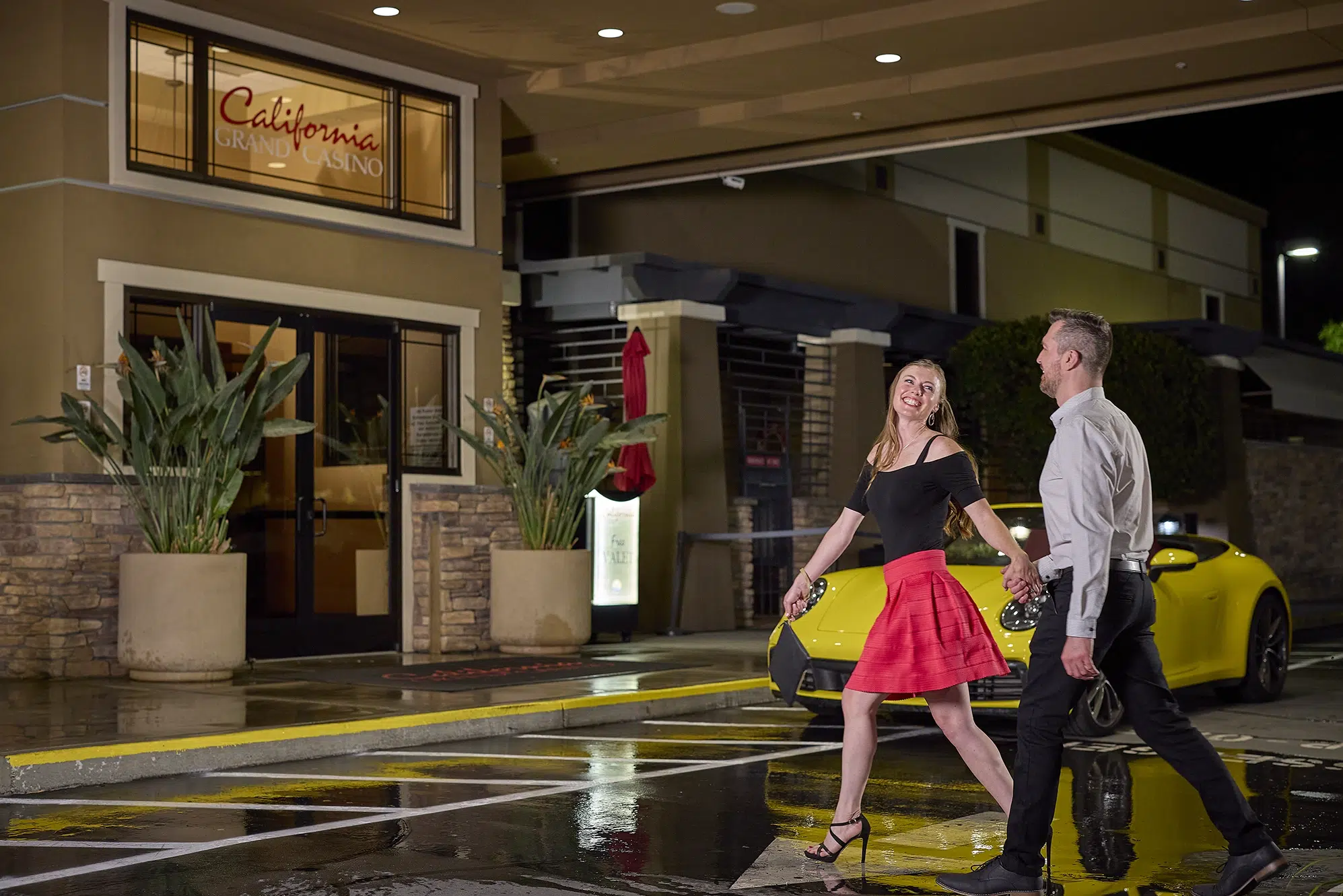 Happy couple arriving at California Grand Casino entrance, ready to enjoy table games, dining, and entertainment