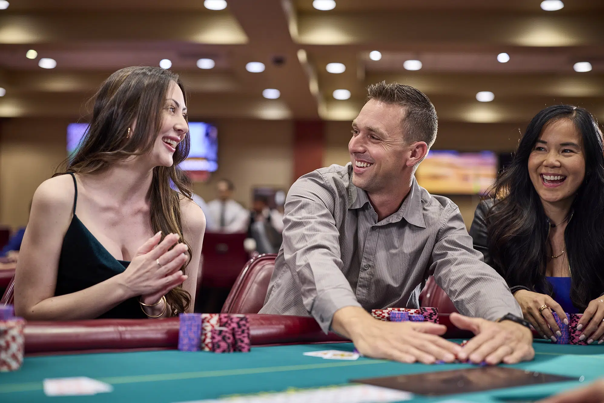 Players smiling and enjoying a live poker game at California Grand Casino