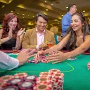 Smiling poker players at California Grand Casino celebrating a big win with stacks of chips on the table